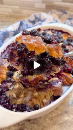 a bowl filled with blueberry cobbler on top of a counter