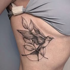 a woman's stomach with a bird tattoo on it