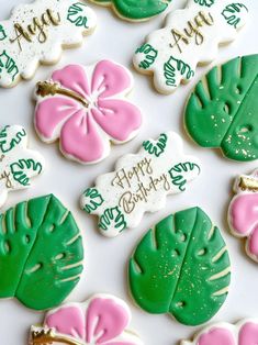 decorated cookies with pink, green and white frosting are arranged on a table top