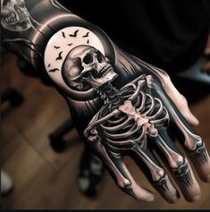 a man's hand with a skeleton and moon tattoo on it