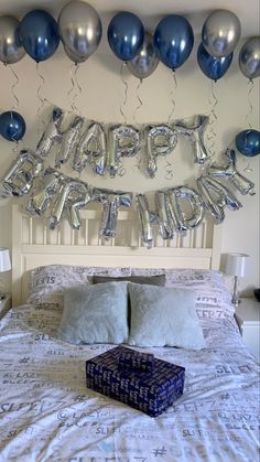 a bed with silver and blue balloons on it