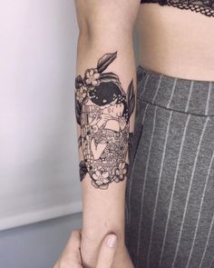 a woman's arm with a tattoo on it that has an image of a bird and flowers