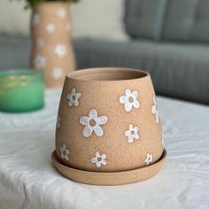 two flower pots sitting on top of a table