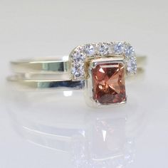 a ring with an orange and white diamond in it