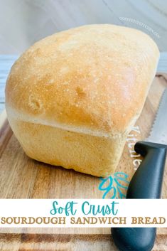 a loaf of sourdough sandwich bread on a cutting board with a knife next to it