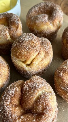 powdered sugar covered donuts sitting on top of a table