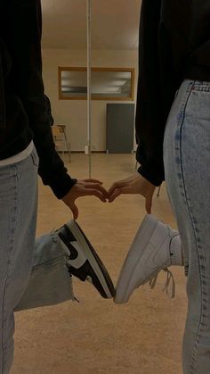 two people holding hands in the shape of a heart