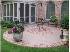 a brick patio with potted plants and chairs around it in front of a house