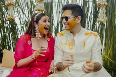 a man and woman sitting next to each other with food on their faces in front of them