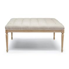 an upholstered bench with wooden legs and a beige cushion on the top, against a white background