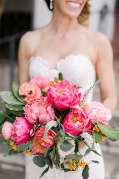 a bride holding a bouquet of pink flowers