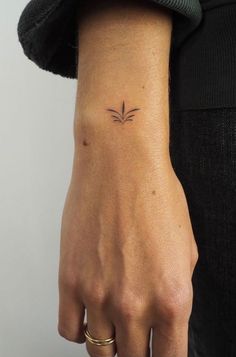 a woman's arm with a small tattoo on the left side of her wrist