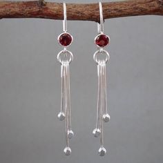 "Beautiful and elegant handmade earrings featuring a natural faceted Garnet gemstone and three dangles of descending lengths. Each dangle element has been handcrafted individually from a sterling silver wire. The end of wire has been melted into a small ball with a jeweller's torch and the ball was flattened with a hammer. The dangles of varying length are suspended from a small sterling silver circle. The earrings have been polished to a bright and shiny finish. They are available in a choice of 3 different gemstones. Please select your stone from the drop-down menu when placing your order. Garnet is January's Birthstone and the gemstone for the 2nd, 6th and 19th wedding anniversaries. It symbolises peace, prosperity, good luck and good health. Garnets are considered an ideal token of tru Sterling Silver Linear Earrings With Dangling Beads For Gift, Elegant Sterling Silver Crystal Earrings With Dangling Beads, Sterling Silver Minimalist Dangle Crystal Earrings, Minimalist Sterling Silver Dangle Crystal Earrings, Sterling Silver Dangle Crystal Earrings, 19th Wedding Anniversary, Garnet Birthstone, Star Garnet, Wedding Bridesmaid Jewelry