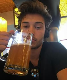 a man is drinking from a beer mug