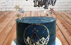 a black cake with gold stars on top and the words happy birthday written in large letters