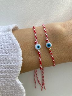 "Keep yourself protected with this Greek March/evil eye bracelet. It is a tradition dating back to antiquity and is used to protect the wearer from sunburn and evil.  D E T A I L S  *It features a small glass evil eye charm on the traditional red and white cotton cord that is used in a Greek March bracelet - \"martaki\" *Choose between a gold filled or sterling silver bead. *Bracelet is adjustable. Just move the slider bead holding the cords up or down. P A C K A G I N G: All our products are gi White Round Beaded Bracelet For Good Luck, Spiritual White Bracelets For Good Luck, White Spiritual Bracelet For Good Luck, Spiritual White Bracelet For Good Luck, Handmade White Good Luck Bracelets, Adjustable White Bracelet For Good Luck, Handmade White Evil Eye Spiritual Bracelet, Handmade White Evil Eye Bracelet Gift, Handmade White Spiritual Evil Eye Bracelet