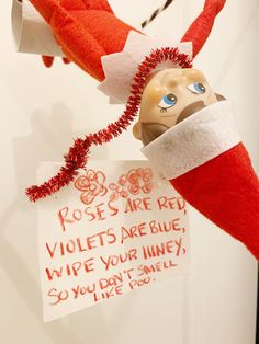 an elf's hat hanging from the ceiling with a sign on it that says roses are red violets are blue wipe your linens so you don't smell