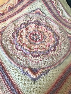 a crocheted blanket is laying on the floor