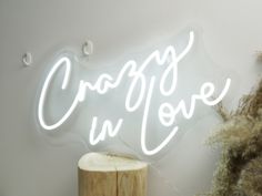 a white neon sign that says crappy in love on the side of a wall