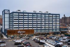 a parking lot filled with lots of cars next to a tall building