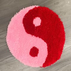 a red and pink rug with the shape of a yin - yang symbol on it