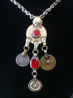 "This is a really great piece. The pendant consists of old coins teamed with a couple of red synthetic stones with the addition of patterned medallions & is suspended on a handmade chain with a \"S\" hook closure. This is a really aesthetically pleasing piece....a joy for the eye!" Vintage Metal Coin Pendant Necklace, Festival Medallion Necklace With Coin Pendant, Festival Coin Pendant Necklace In Medallion Shape, Festival Coin Pendant Medallion Necklace, Traditional Medallion Necklace With Vintage Charm, Traditional Necklaces With Vintage Charm And Round Pendant, Vintage Medallion Coin Necklace With Large Pendant, Antique Red Necklace With Large Pendant, Traditional Red Medallion Necklace