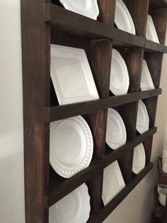 a wooden shelf with white plates on it