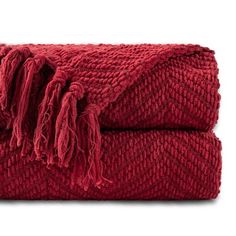 a red blanket with fringes on the top and bottom is folded in two rows