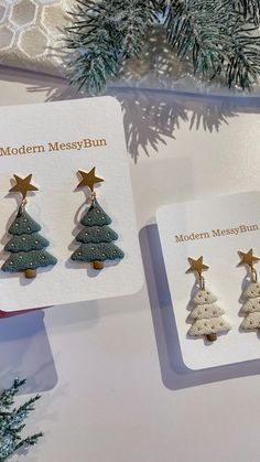 three christmas tree earrings are on display