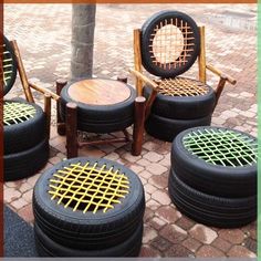 four chairs made out of old tires sitting in the middle of a brick floored area