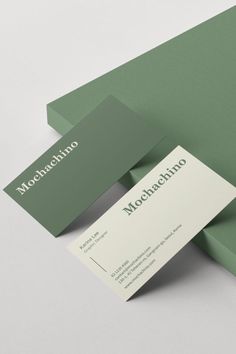 two green business cards on top of each other with the word moochachino printed on them