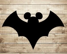 the silhouette of a bat on a wooden background