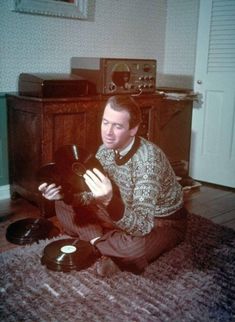 a man is sitting on the floor with his hair dryer in front of him