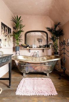 a bathroom with a claw foot tub and pink walls