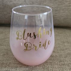 a pink wine glass with gold lettering that says,'blushing bride'on it