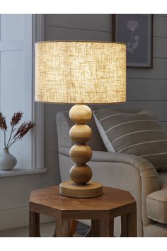 a lamp that is sitting on top of a table in front of a couch and chair