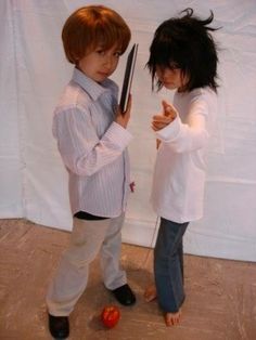 two people standing in front of a white backdrop one holding a knife and the other pointing at something