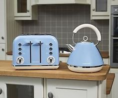 two blue toasters sitting on top of a wooden counter in a kitchen next to an oven