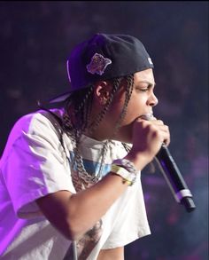 a man with dreadlocks on his head holding a microphone in front of him