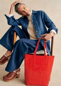 a person sitting on a chair with a red bag