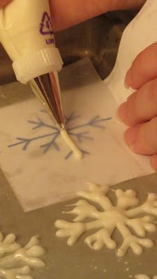 someone is decorating a snowflake with white icing