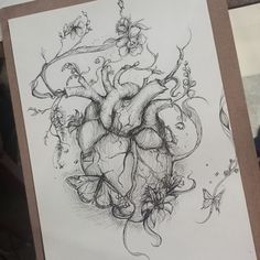 a drawing of a heart surrounded by vines and flowers on a piece of white paper