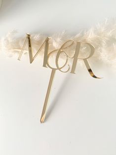 a cake topper with the word mr and mrs spelled in gold letters on it