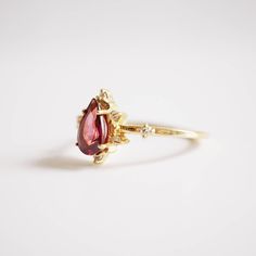 A beautiful garnet set in 14K solid gold. The gorgeous ring for an understated classy look. Handcrafted in your choice of 14K Yellow gold, Rose gold and white gold. A classy piece to treasure for time to come. Materials: - 14K solid gold - 7x5mm natural pear-shaped garnet stone - Round CZs (what's this?) ** This item is specially made for you. Please allow 1-2 week lead time. Shipping: Domestic: Free standard shipping within the U.S. International: Free standard shipping for orders over $150 Cus Elegant Pear-shaped Yellow Gold Birthstone Ring, Fine Jewelry 14k Gold Pear-shaped Ruby Ring, Elegant Teardrop Ruby Rings, 14k Gold Pear-shaped Ruby Ring, Elegant Yellow Gold Pear-shaped Birthstone Ring, Timeless Pear-shaped Ring For Gift, Timeless Pear-shaped Rings For Gifts, 14k Gold Pear-shaped Birthstone Ring, Elegant Pear-shaped Yellow Gold Ruby Ring