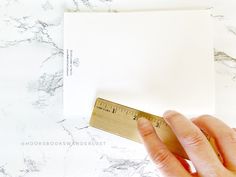 a person holding a ruler next to a piece of paper