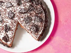 a chocolate cake on a white plate with one slice cut out and ready to be eaten