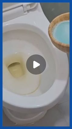 a white toilet sitting next to a wooden bowl filled with liquid on top of it