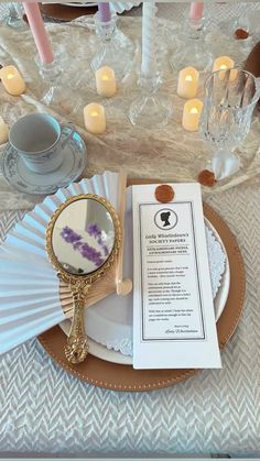 a table set with plates, napkins and candles