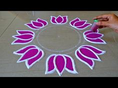 someone is making a pink and white flower design on the floor with felt glues