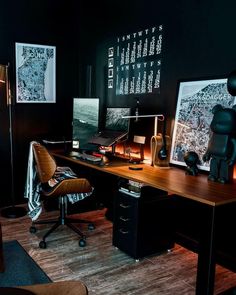 an office with black walls and wood floors, including a wooden desk topped with a chair